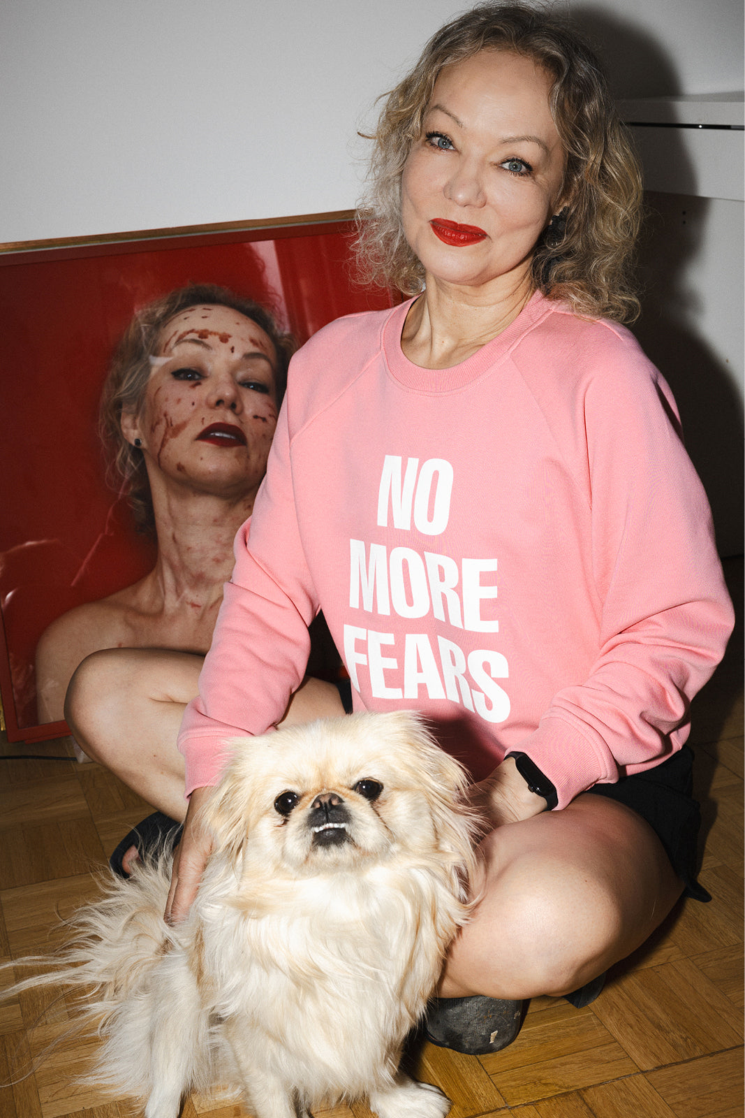 Kobieta w różowej bluzie z napisem 'NO MORE FEARS' z psem, stylowa odzież damska z kulturą i wygodą