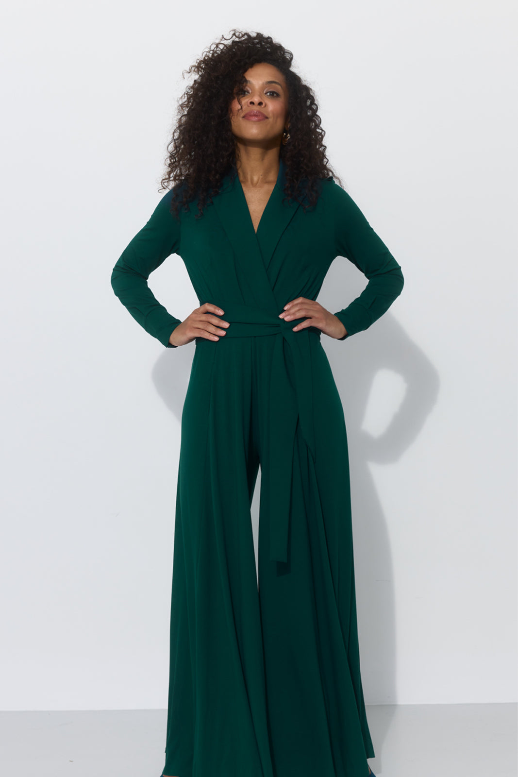 Zielony jumpsuit z długim rękawem i wiązanym pasem, elegancka stylizacja na co dzień
