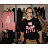 Kobieta w czarnej koszulce z napisem 'NO MORE FEARS', stylowy i wygodny strój z polskiej marki