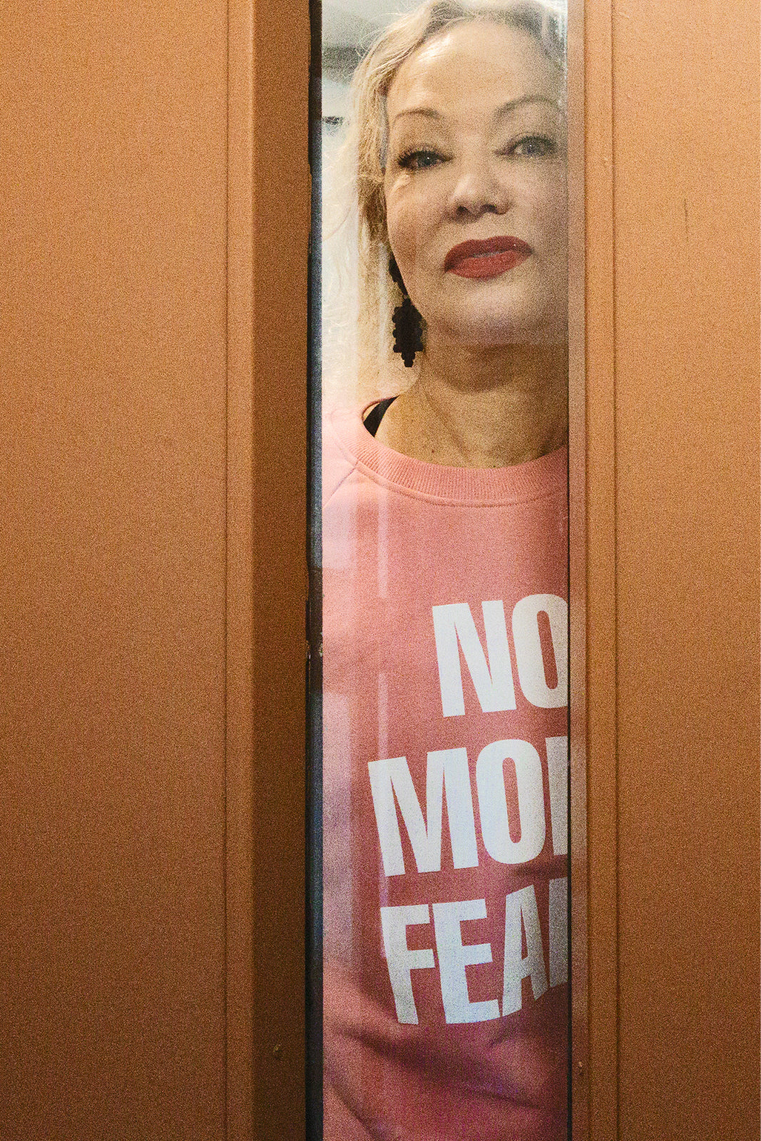Kobieta w różowym swetrze z napisem NO MORE FEAR, modny i wygodny, idealny na codzień