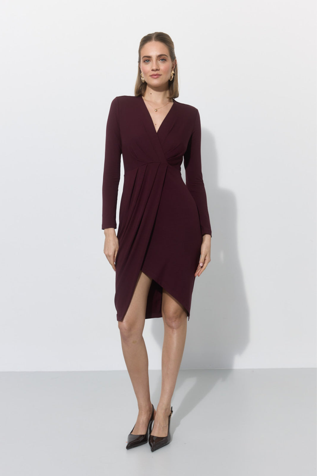 Elegancka sukienka w kolorze bordo z asymetryczną linią do kolan, idealna na codzienne stylizacje